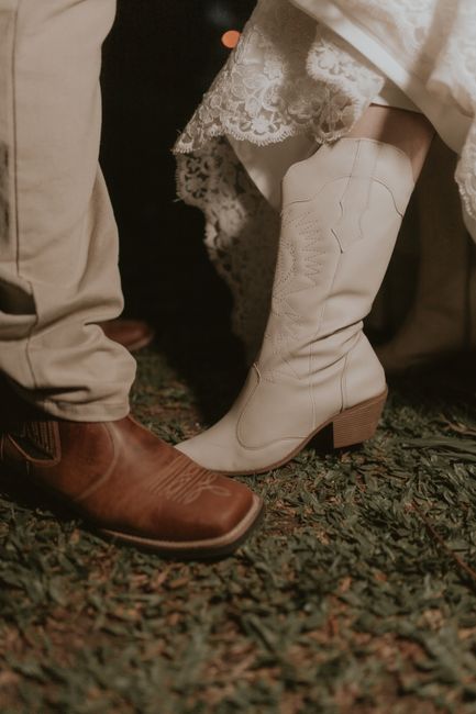 A group of people dancing in western attire with cowboy boots on a wooden dance floor.