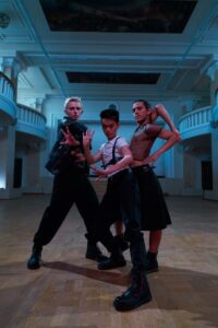 Dancers in boots practicing synchronized country line steps on a wooden floor.