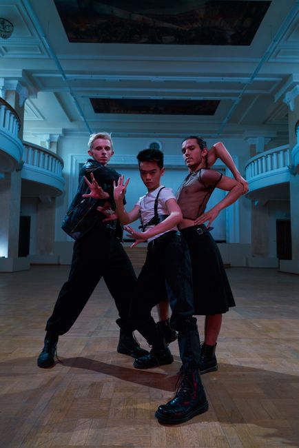 Dancers in boots practicing synchronized country line steps on a wooden floor.